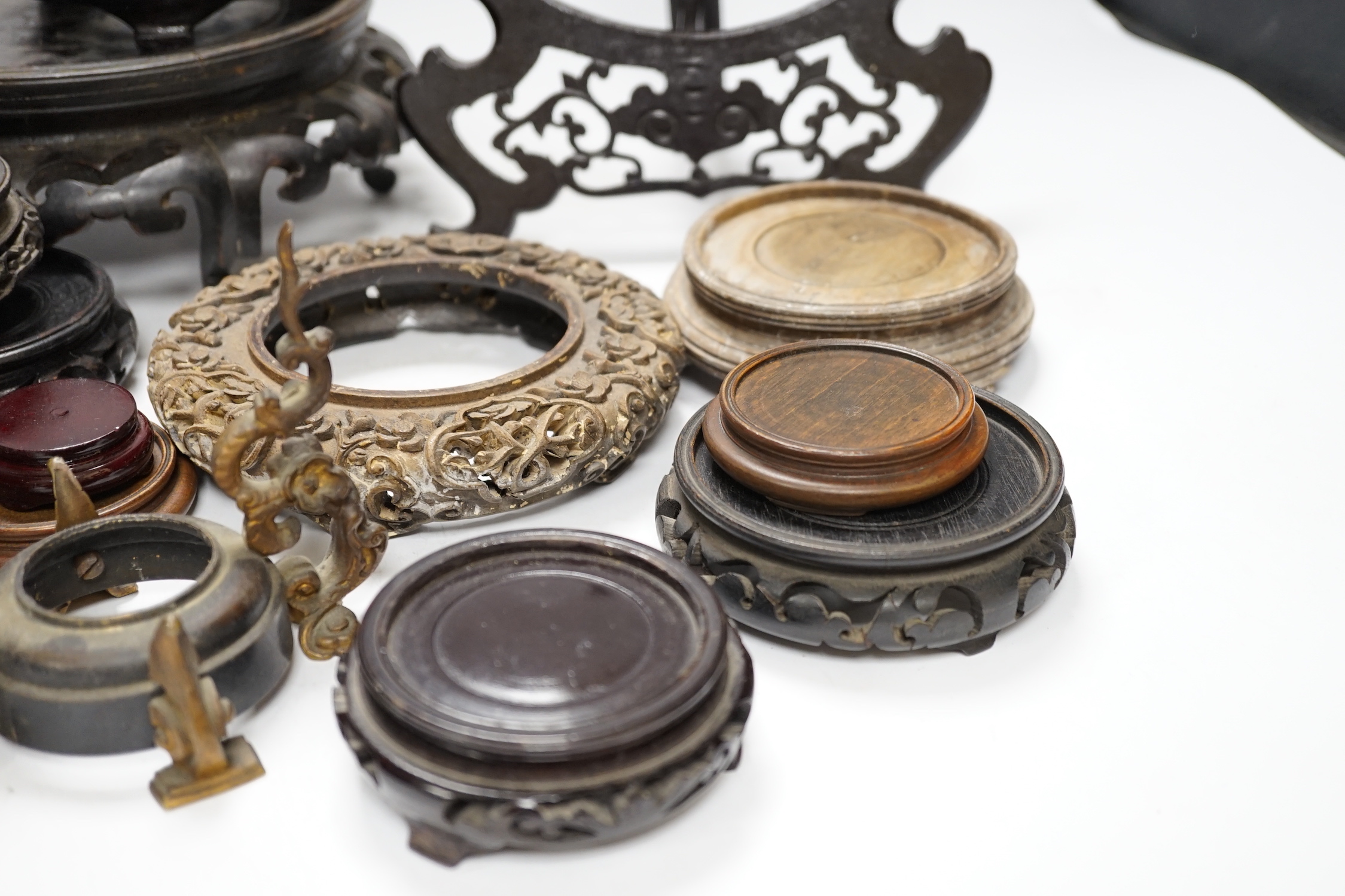 Assorted Chinese wooden and metal stands, largest 25cm in diameter